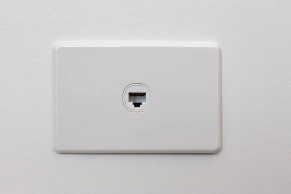 Network connection wall outlet on white wall with copy space
