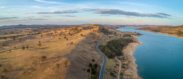Aerial view of rolling landscape and river at sunset in Australia