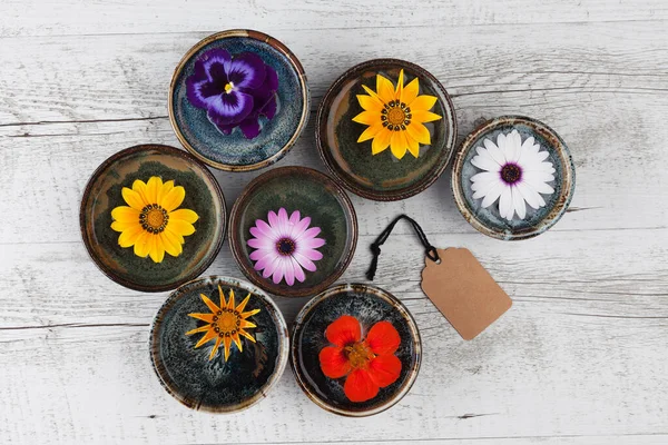 Färgglada Blommor Flyter Vatten Små Keramiska Skålar Rustika Träbord Med — Stockfoto