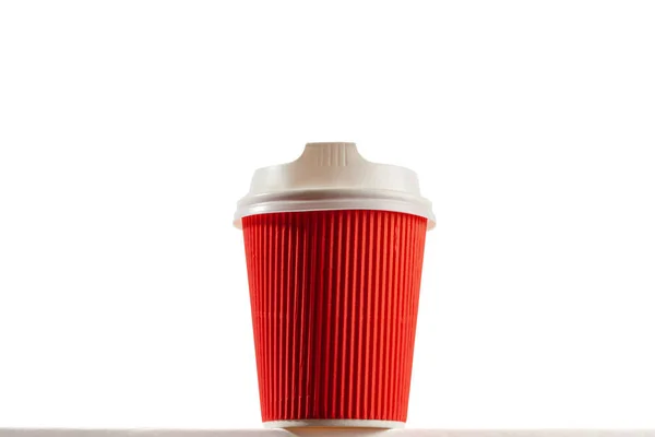 コピースペース付きの白い背景に蓋付きの赤い使い捨てコーヒーカップ クローズアップヒーローの外観 — ストック写真