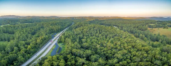 Aerial panorama of Pacific Highway and forests in rural area at sunset. NSW, Australia