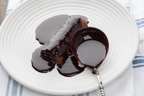 ホワイトプレート上にヴィンテージシルバースプーンとダークチョコレートで覆われた甘いチューブの閉鎖 — ストック写真