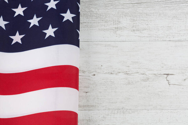 Американский флаг сложили на белом деревенском деревянном столе. Горизонтальное изображение с копировальным пространством
