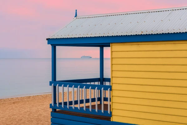 Żółta Chata Plaży Widokiem Rejs Liniowcem Płynącym Przez Wodę Różowym — Zdjęcie stockowe