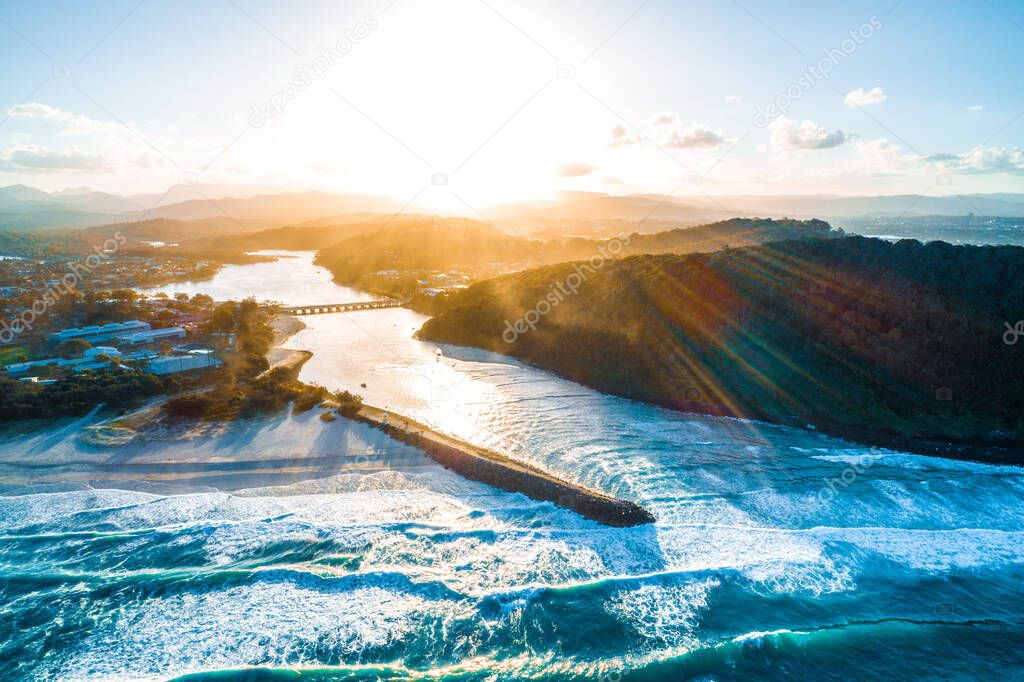 Aerial view of sunset over Tallebudgera creek and Palm Beach suburb in Gold Coast, Queensland, Australia