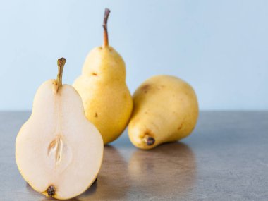 Tam ve yarıya indirilmiş sarı Corella armutları.