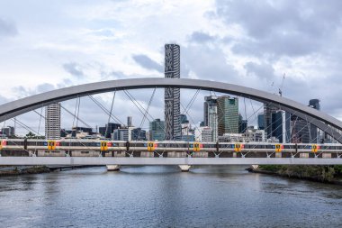 Brisbane nehri üzerindeki Merivale Köprüsü 'nden geçen tren arka planda modern yüksek katlı.
