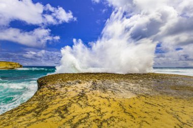 Büyük dalgalar bir kayanın üzerinde patlar. Büyük Okyanus Yolu, Avustralya.
