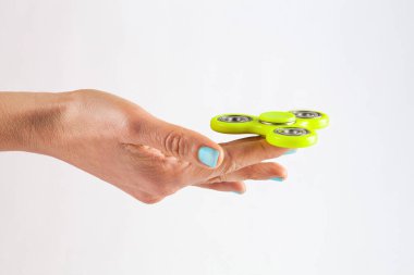 Orman Buğusu renkli tırnakları olan kadın eli, beyaz zemin üzerinde izole edilmiş sarı kıvrım döndürücü tutuyordu.