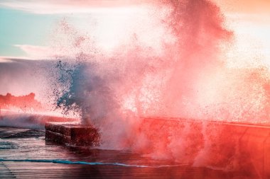 Gün batımında Mornington İskelesi ve Breakwater 'da büyük dalgalar şiddetle eziliyor. Melbourne, Avustralya