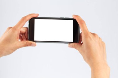 Kadın eller cep telefonunu yatay doğrultuda tutuyor. Beyaz ekran ile izole edilmiş.