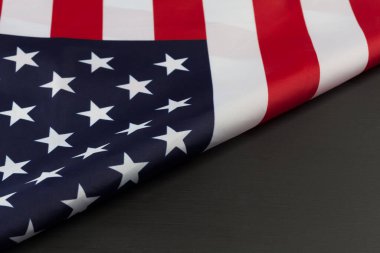 Amerikan bayrağının katlanmış bir parçası siyah karatahtanın üzerinde. Çapraz kopyalama alanı olan yatay resim.