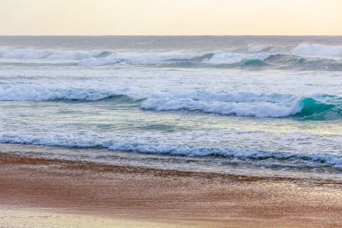 Gün batımında okyanus dalgaları ve kumsal kumu - sakin manzara