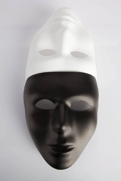 Máscaras Blancas Negras Unidas Sobre Fondo Reflectante Blanco Imagen Vertical —  Fotos de Stock