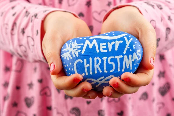 Młode Dziecko Ręce Trzymając Niebieski Malowany Kamień Merry Christmas Pisowni — Zdjęcie stockowe