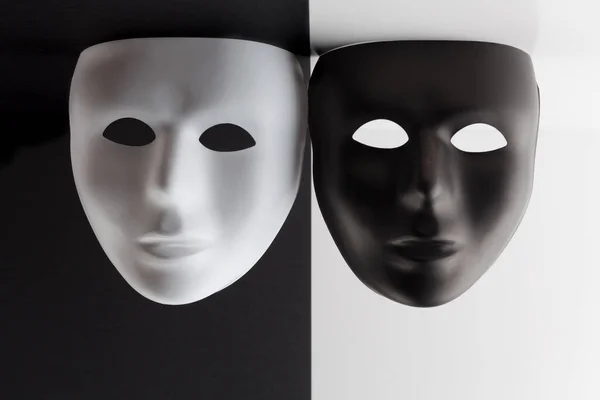Schwarz Weiße Masken Auf Kontrastierenden Hintergründen Hängen Von Der Decke — Stockfoto