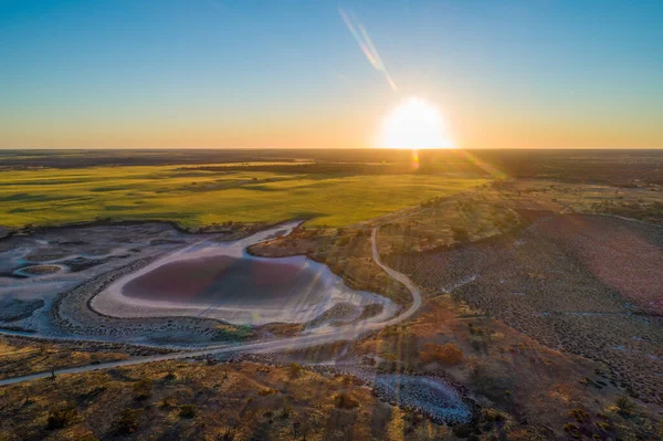 Sunset with sun flare over agricultural land and desert in Australia