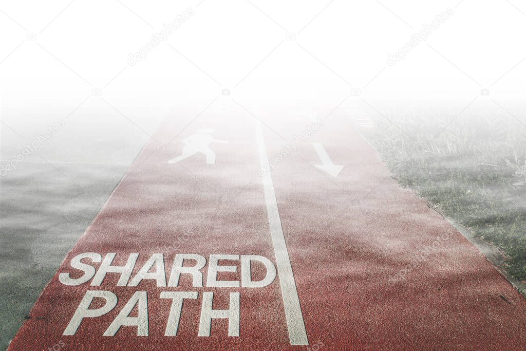 Shared Path sign written on footpath for cyclists and pedestrians with bicycle, walking person, and arrow signs disappearing in white fog