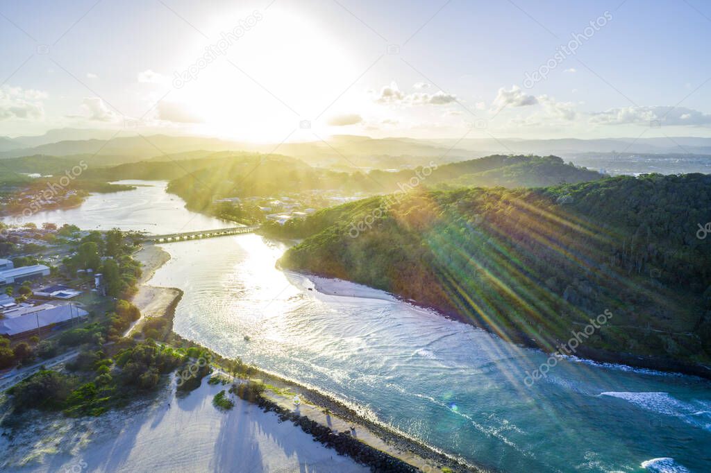 Aerial view of sunset with sun flare over Tallebudgera creek in Gold Coast, Queensland, Australia