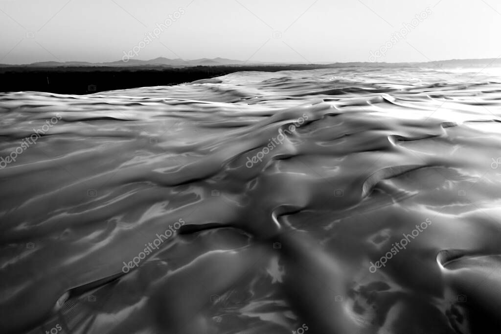 Sand dunes at sunrise in black and white