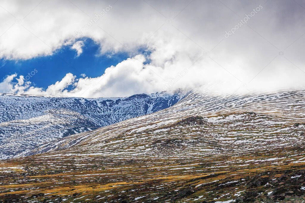Mountains covered in snow under fluffy clouds landscape