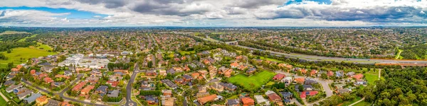 Melbourne, Avustralya 'da bulutlu bir günde Mulgrave banliyösü ve Eastlink otoyolunun geniş hava manzarası