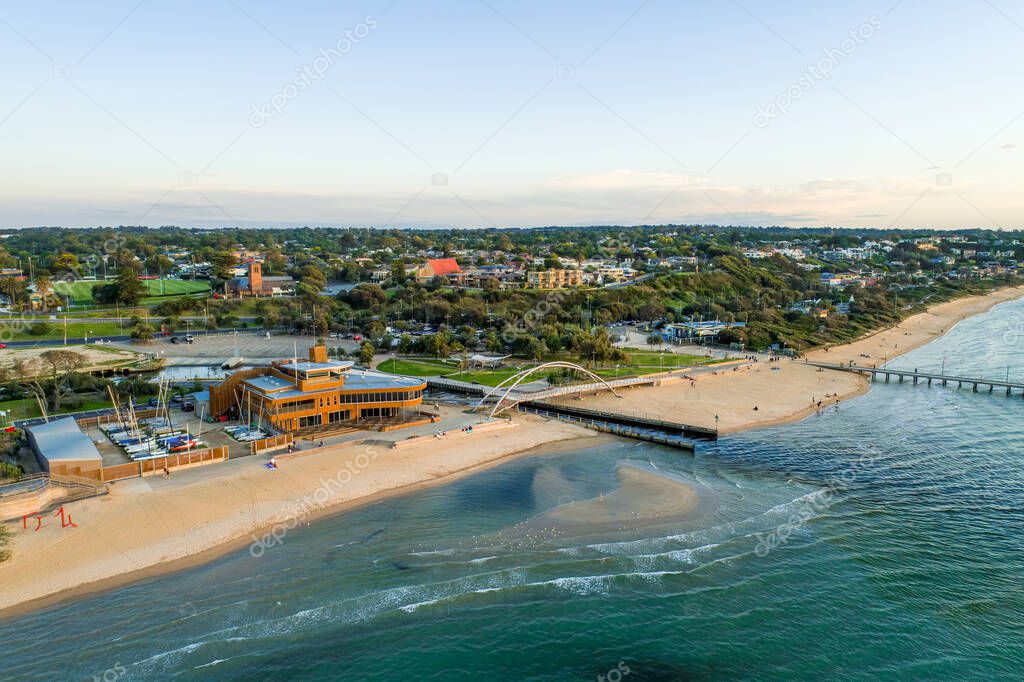 Aerial view of Frankston Yacht Club and footbridge over Kananook creek at the foreshore at sunset.