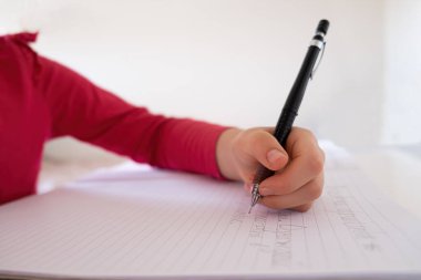 Defterde sığ odaklı mekanik kalemle beyaz çocuk el yazısı