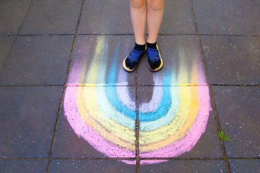 Tebeşir üzerinde duran çocuk ayakları Gökkuşağı çizgisi