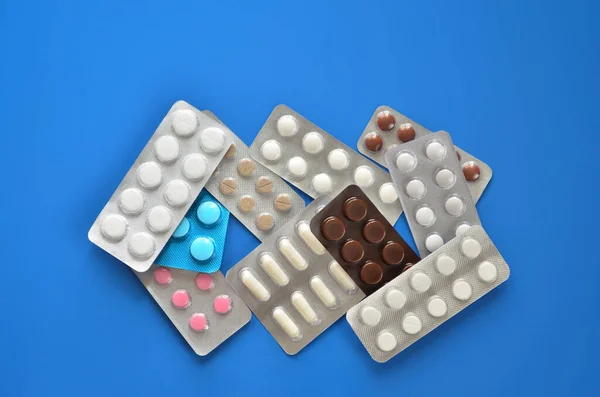 Heap various pills in blister pack on a blue background — Stock Photo, Image