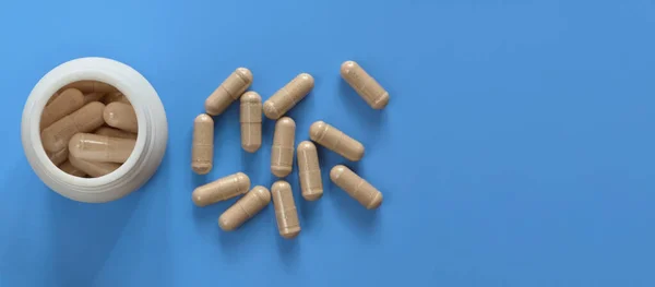 Weiße Arzneiflasche Mit Medikament Und Verstreuten Kapseln Auf Hellblauem Hintergrund — Stockfoto