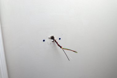 Kurulum sırasında duvardan çıkan bir HVAC ünitesi ile kullanılan termsotat için kontrol kablosu