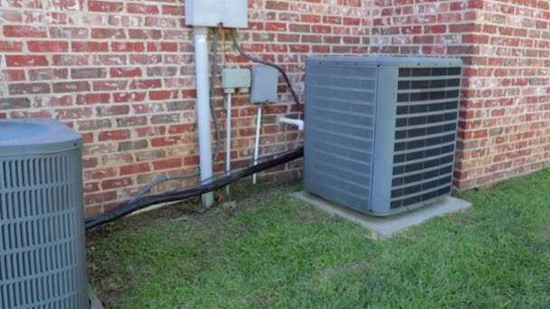 Dolly shot of air conditioner units next to brick home — Stock Video