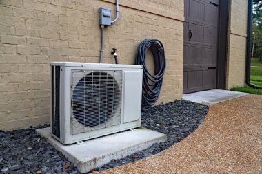 Air Conditioner mini split system next to home with painted brick wall clipart