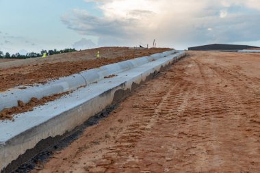İnşaat halindeki yeni bir yol için yeni beton kaldırım döşendi