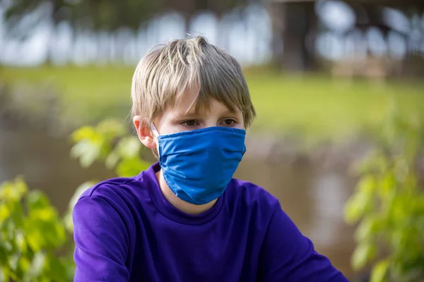Boy wears a face mask, while wondering about the future during the COVID19 pandemic
