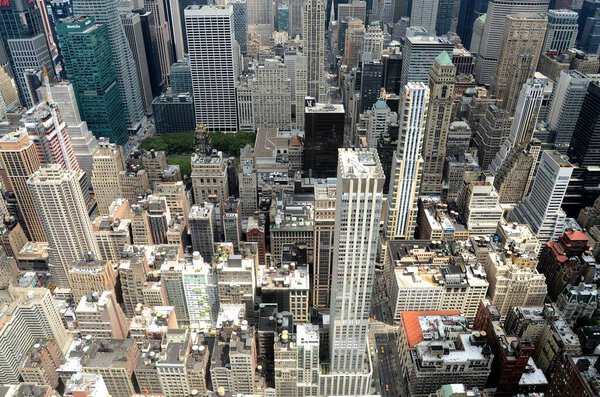 Aerial view of skyscrapers, rooftops, and buildings from the Empire State Building, looking toward the direction of uptown Manhattan on a beautiful and sunny August summer day, New York City, United States of America.