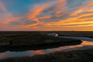Sankt (St.) Peter Ording, Almanya yakınlarındaki muhteşem renklerle ve dramatik gökyüzüyle Kuzey Denizi 'nde büyüleyici bir gün batımı.