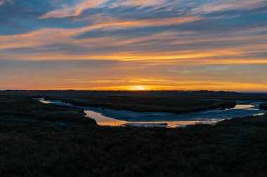 Sankt (St.) Peter Ording, Almanya yakınlarındaki muhteşem renklerle ve dramatik gökyüzüyle Kuzey Denizi 'nde büyüleyici bir gün batımı.