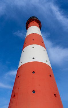 Sankt (St.) yakınlarındaki deniz feneri Westerhever. Gün batımında güzel çarpıcı gökyüzü ve dramatik bulutlarla Peter sipariş veriyor.