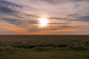 Sankt (St.) yakınlarındaki deniz feneri Westerhever. Gün batımında güzel çarpıcı gökyüzü ve dramatik bulutlarla Peter sipariş veriyor.