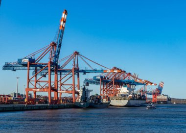 Hamburg konteynır limanında bazı gemiler yük gemilerine konteynır yüklüyor ve naklediliyor.