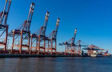 Hamburg konteynır limanında bazı gemiler yük gemilerine konteynır yüklüyor ve naklediliyor.