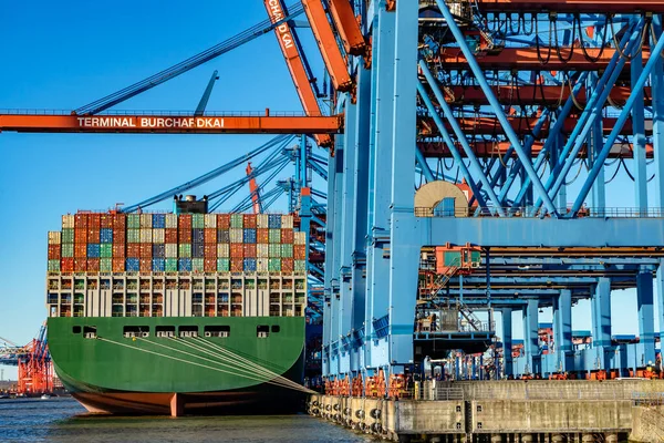 Hamburg konteynır limanında bazı gemiler yük gemilerine konteynır yüklüyor ve naklediliyor.