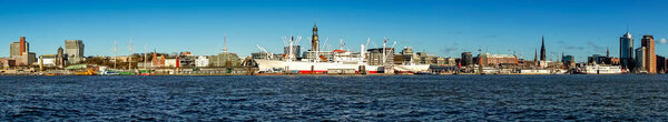 Panorama/Skyline of Hamburg harbor from the opposite side of the Elbe river with the Michel church, TV Tower and the museum ship Cap San Diego