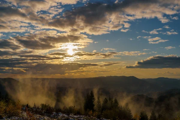 いくつかの霧と曇りの空と黄金の時間で黒い森の山々の夕日のパノラマ — ストック写真