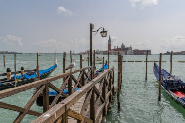 Venedik, İtalya 'daki Grand Canal' daki iskeledeki Gondollar. Arka planda San Giorgio Maggiore Kilisesi.