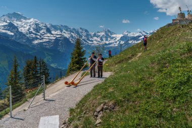 İsviçre 'deki Schynige Platte' de turistleri karşılamak için Alp kornası çalan iki adam.