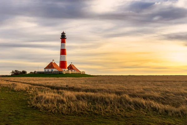 Sankt (St.) yakınlarındaki deniz feneri Westerhever. Gün batımında güzel çarpıcı gökyüzü ve dramatik bulutlarla Peter sipariş veriyor.