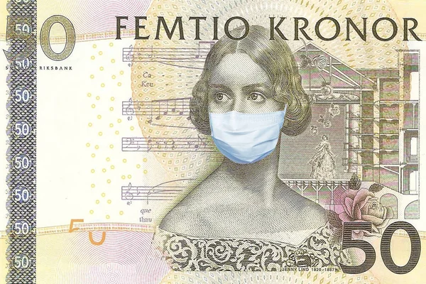 Tıbbi maskeli Astrid Lindgren 'le birlikte 50 kron İsveç banknotu. İsveç 'te koronavirüs salgını. Koronavirüs salgınının İsveç ekonomisi üzerindeki etkisi. İsveç Kronunun devalüasyonu